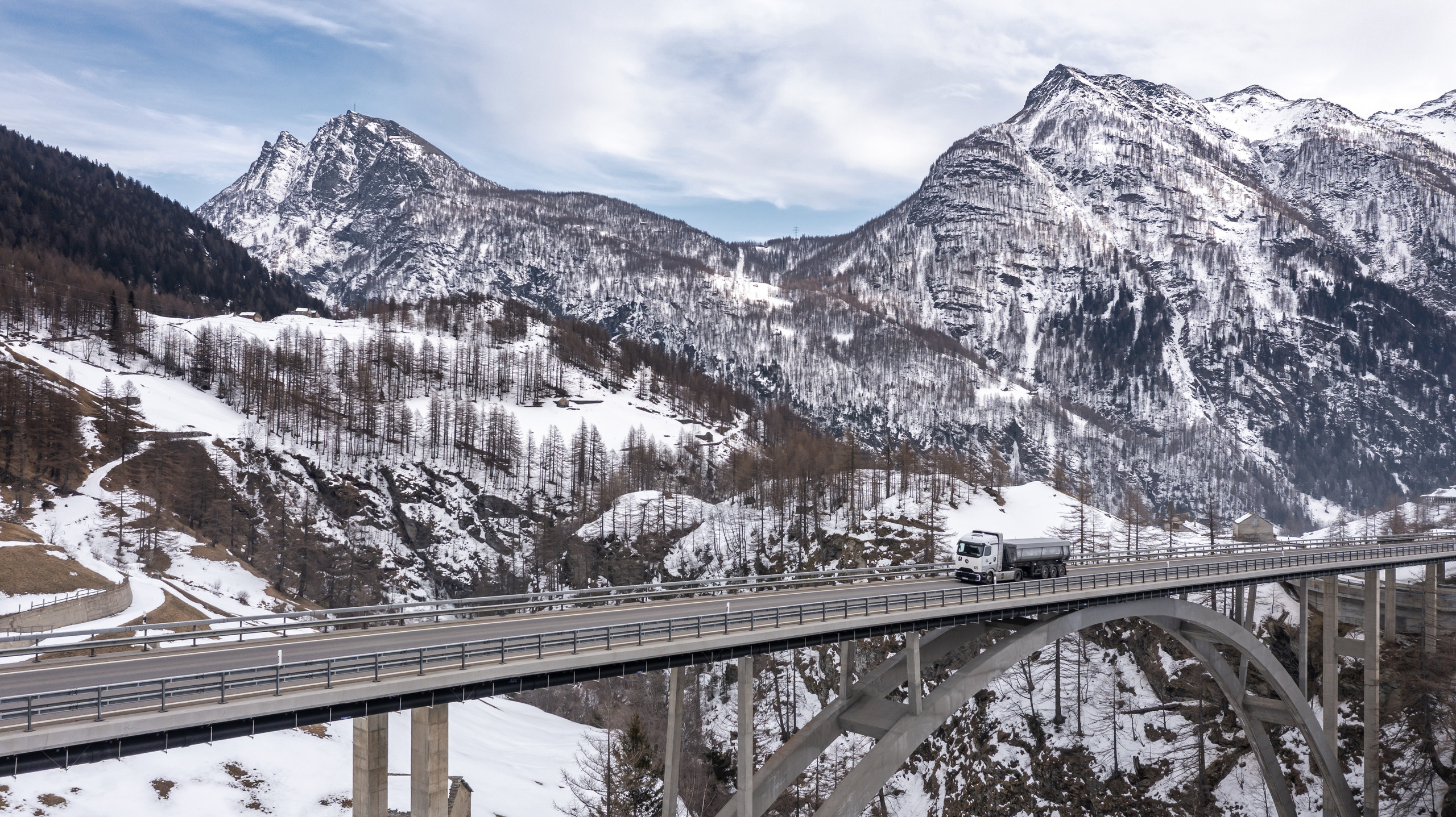 der Lkw GenH2 von Daimler Truck auf einer Brücke, im Hintergrund Teile der Schweizer Alpen