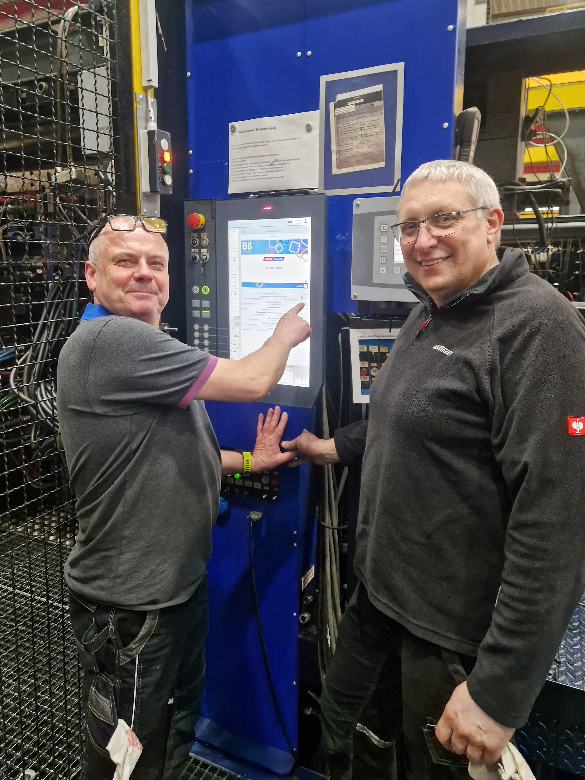 Die Wittmann-Servicetechniker Markus Walus (links) und Reiner Schäl (rechts) beim Retrofit einer Spritzgießgroßmaschine. 