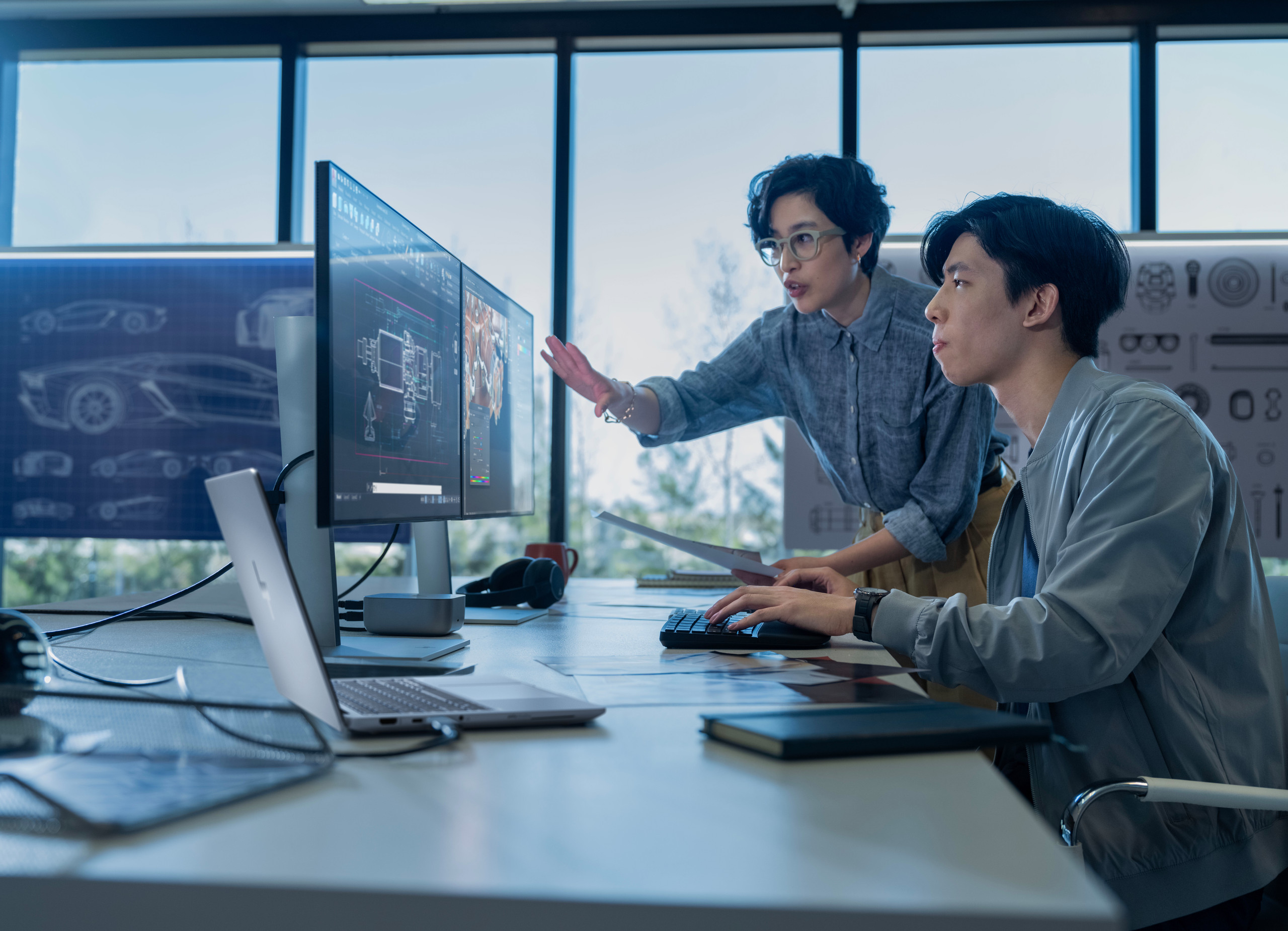 Dank leistungsfähiger Hard- und Software sind Entwickler in der Lage, nicht nur effizienter zu arbeiten, sondern vor allem auch innovativer. <p>Zwei Personen arbeiten in einem modernen Büro an zwei großen Monitoren. Eine Person sitzt und tippt, die andere steht daneben und zeigt auf den Bildschirm. Auf den Monitoren sind technische 3D-Modelle und Konstruktionspläne zu sehen.<p>