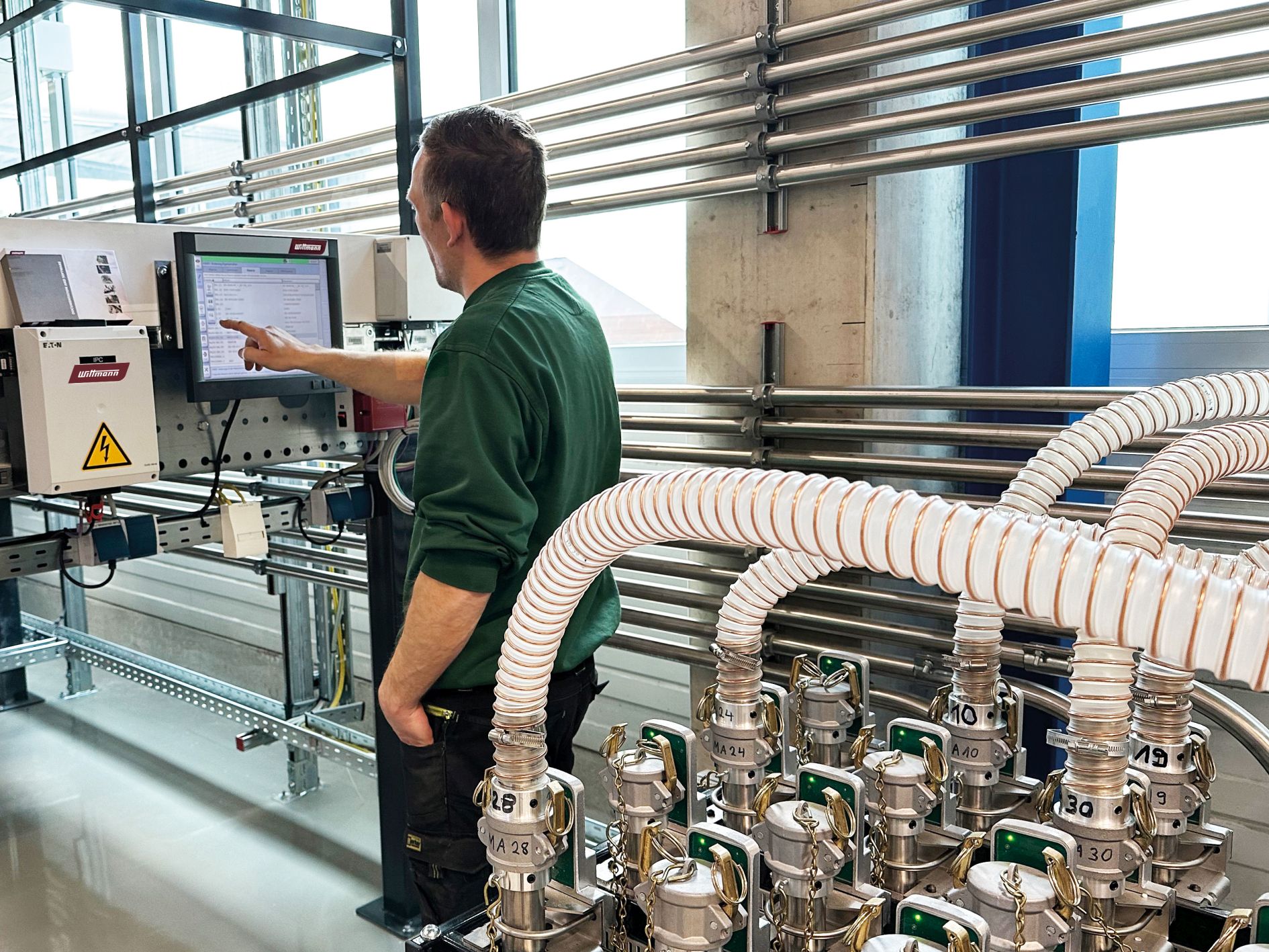 Mann bedient die M8-Steuerung der neuen zentralen Materialversorgungsanlage.