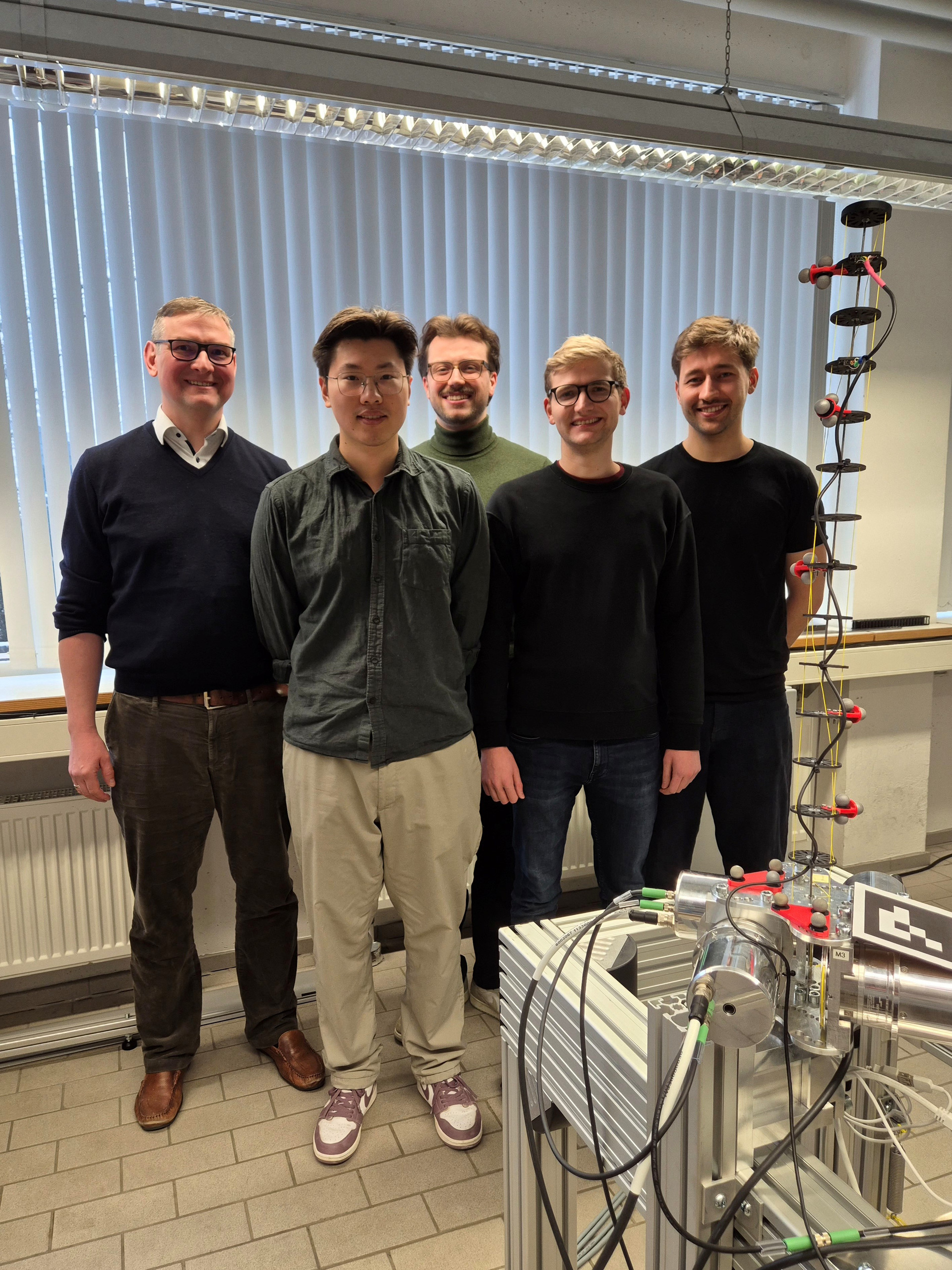 Arbeitsgruppe TU München (von links): Professor Paul Kotyczka, Le Zhang, Stephan Kohlhaas, Maximilian Herrmann und Leander Pfeiffer mit dem Roboterarm