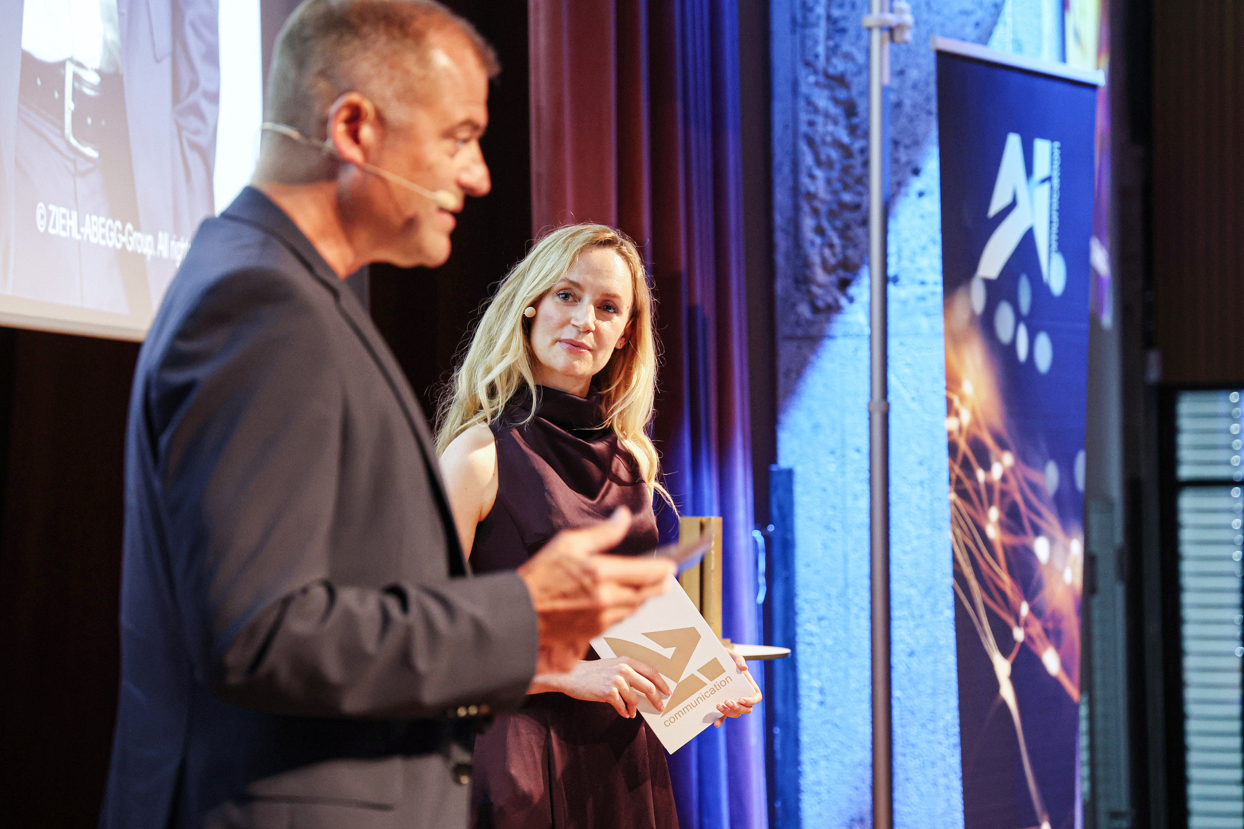AI Communication Award: ein Mann und eine Frau verleihen einen Preis