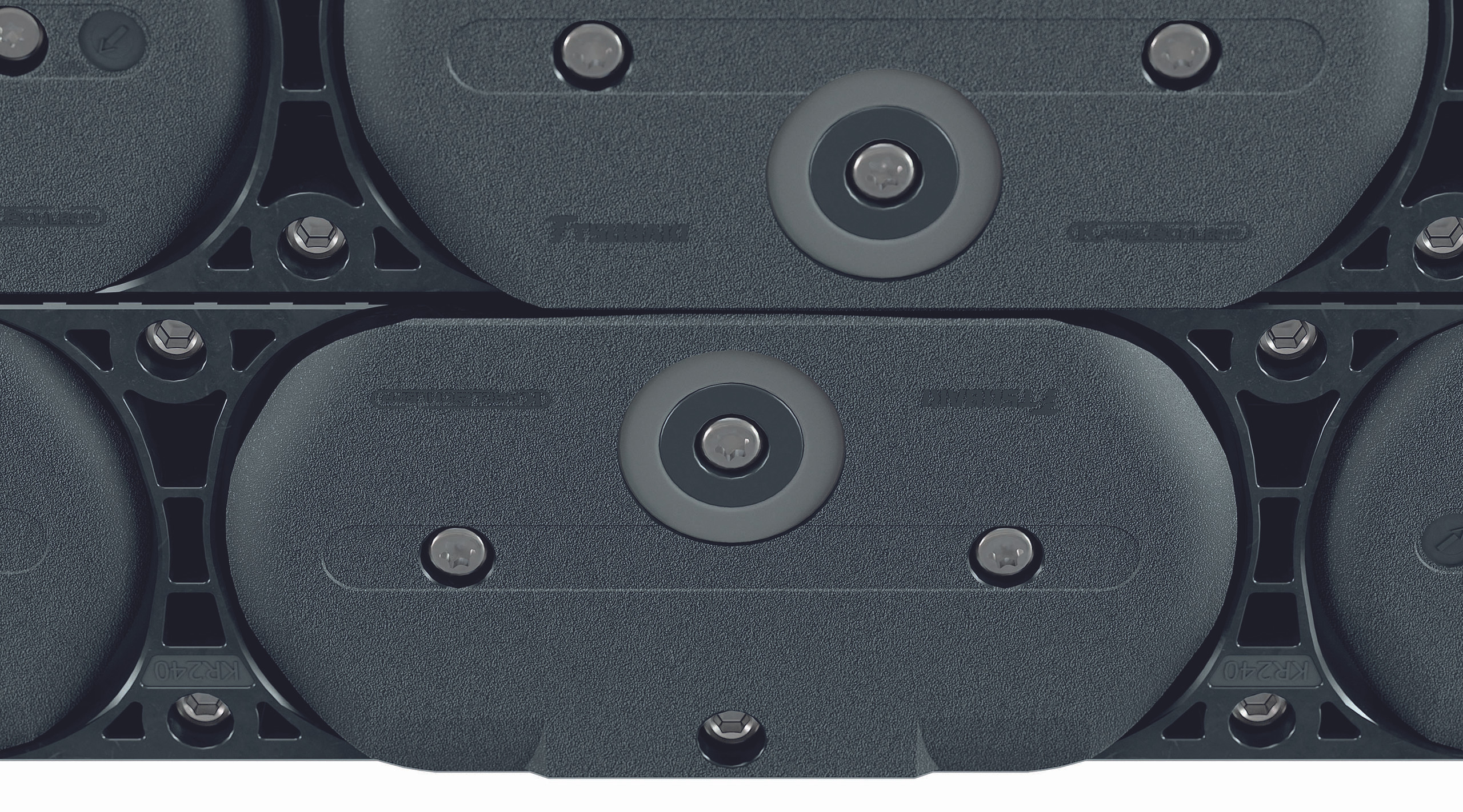 <p>Hier sieht man eine Nahaufnahme von Segmenten einer Energiekette. Die spezielle Oberfläche und die Befestigungselemente sind deutlich sichtbar. Die Segmente sind strukturiert und robust gestaltet, was auf ihre Verwendung in anspruchsvollen Anwendungen hinweist. Die verschiedenen Elemente, wie Schrauben und Aussparungen, deuten auf eine durchdachte Konstruktion hin, die Stabilität und Funktionalität gewährleistet.<p>