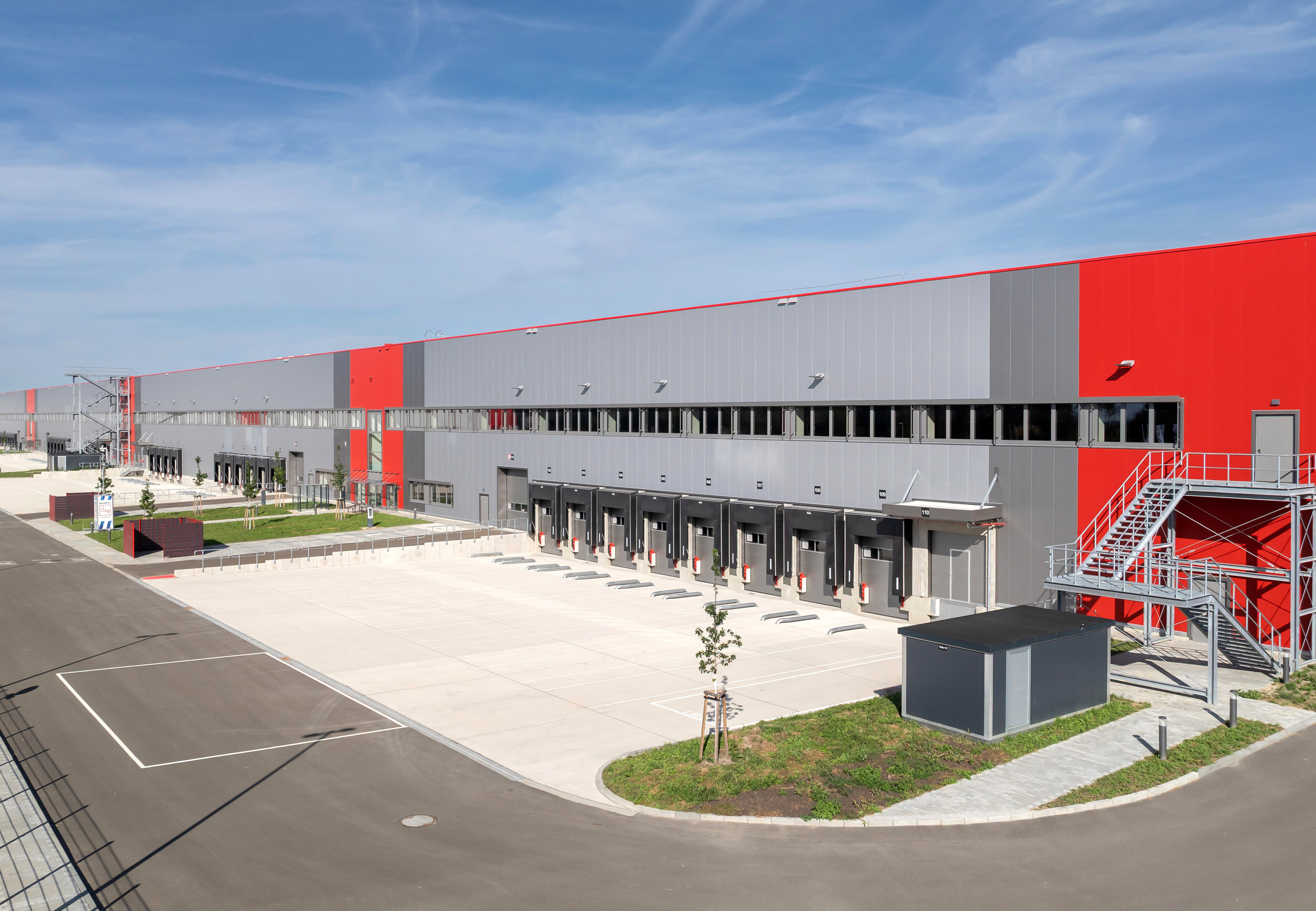 Flachdachbefestigung: modernes Fabrikgebäude in Grau-Rot