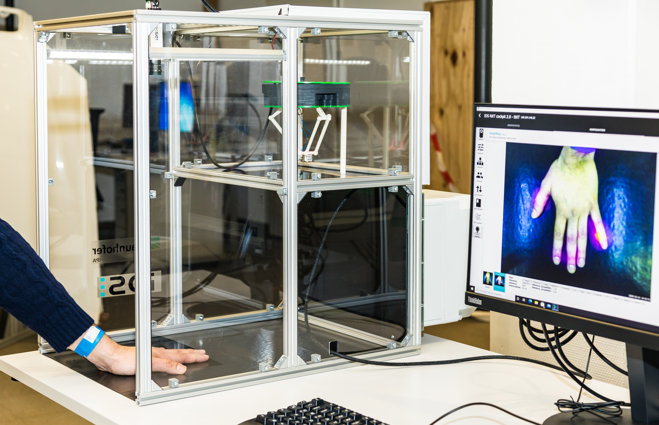 Eine Zelle für Wärmemessungen, darin eine Hand, die auf einem Bildschirm farblich wiedergegeben wird