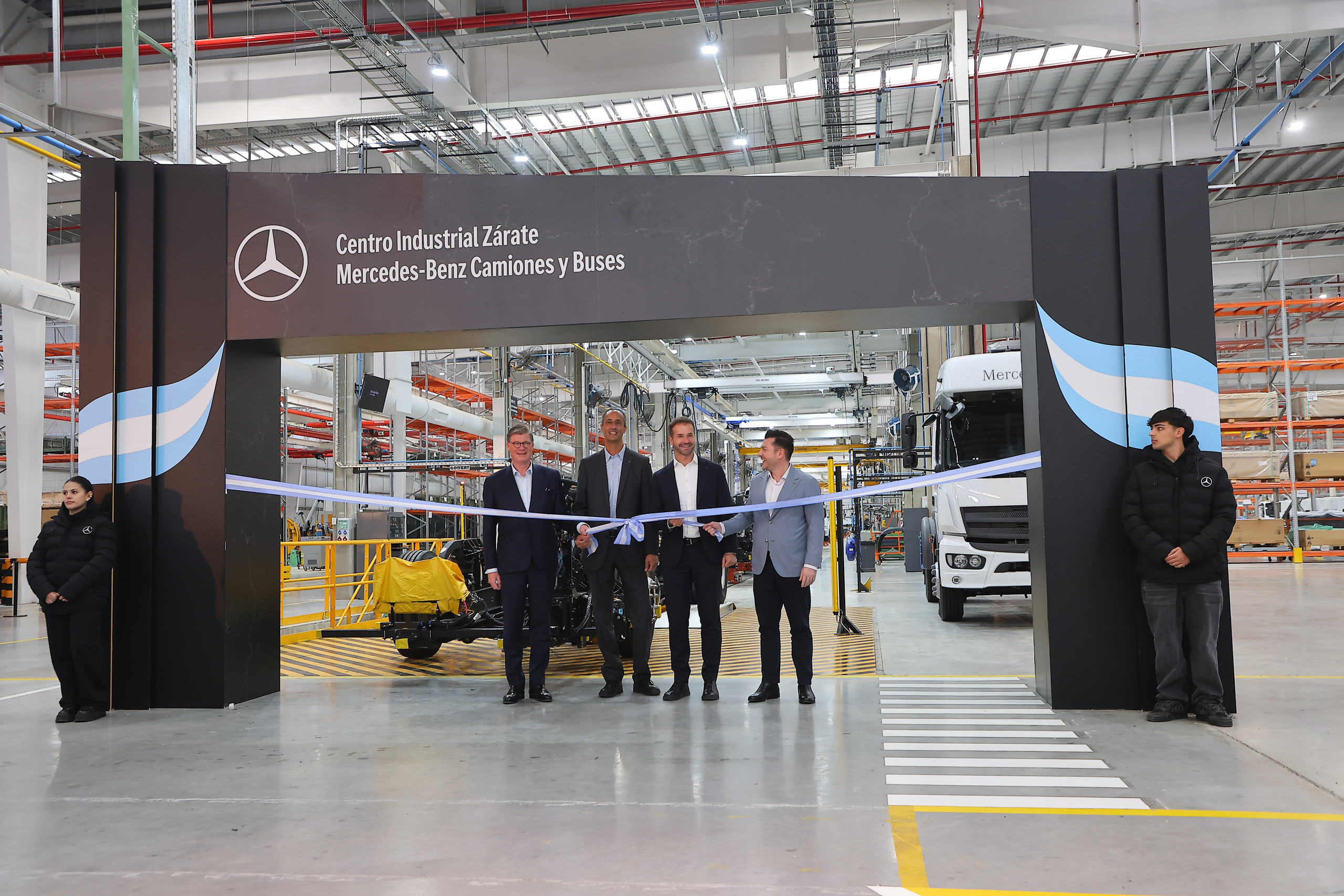 vier Manager von Daimler Truck stehen hinter einem symbolischen Band während der Eröffnung des Werkes im argentinischen Zarate