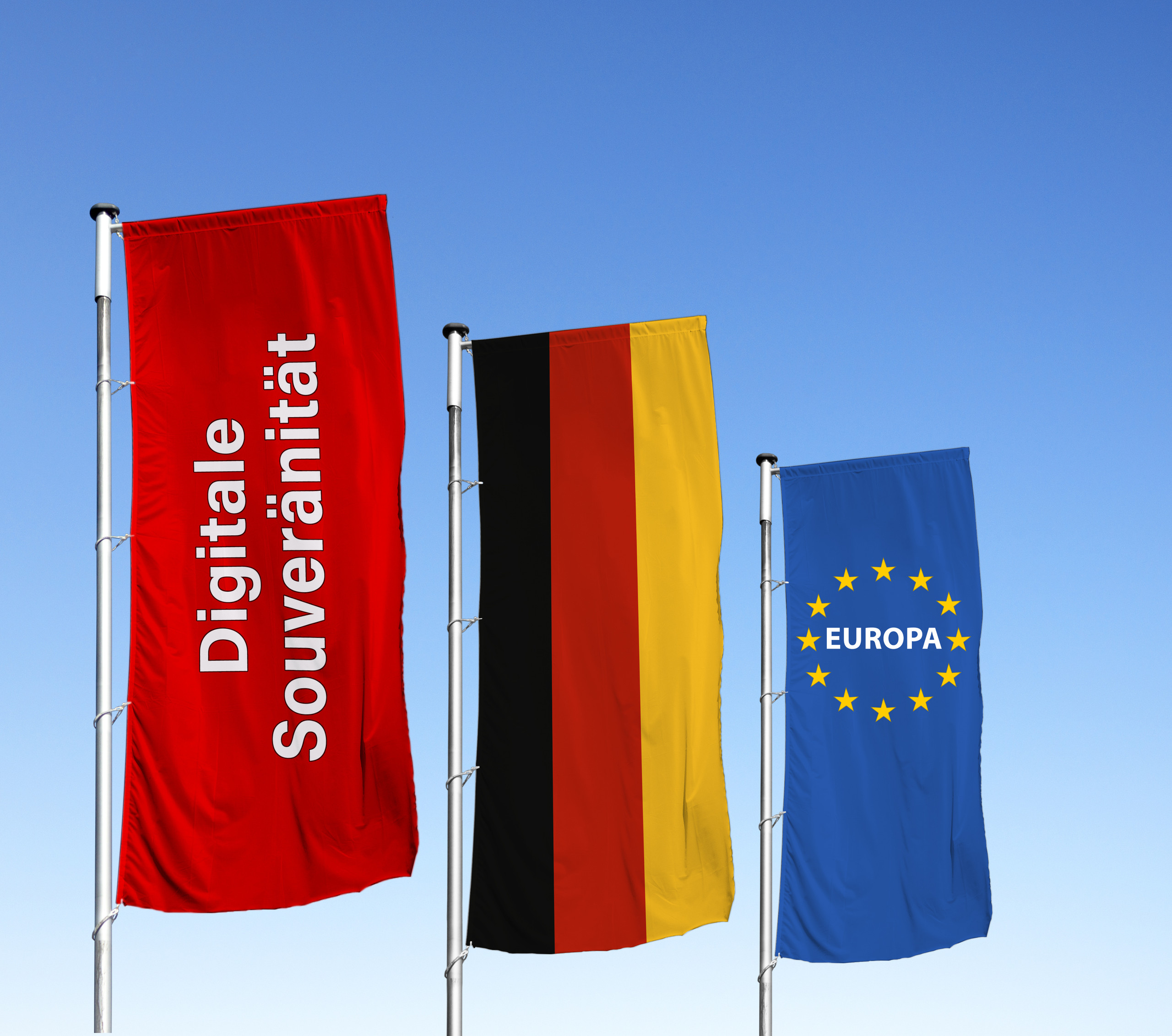 <p>Man sieht: Drei wehende Flaggen vor blauem Himmel: Eine rote Flagge mit der Aufschrift „Digitale Souveränität“, daneben die deutsche Bundesflagge und die europäische Flagge mit dem Schriftzug „EUROPA“ im Sternenkranz. Das Bild symbolisiert die Bedeutung europäischer Rechtsstandards für die digitale Zukunft.<p>