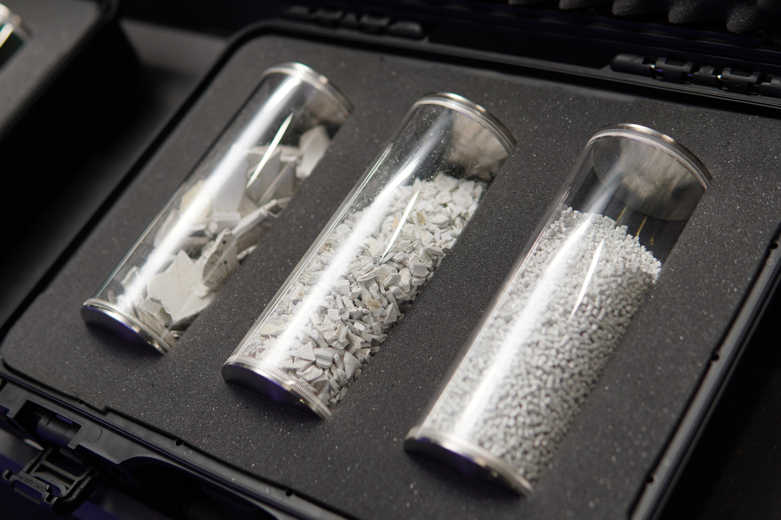 3 Glasröhrchen liegen nebeneinander in einer Box mit weißen Kunststoffteilchen